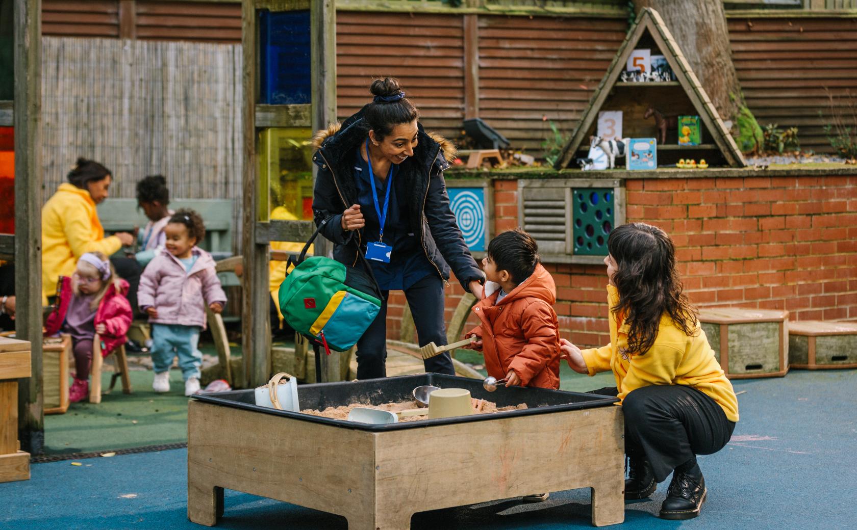 Mum and child at sandpit with child care provider